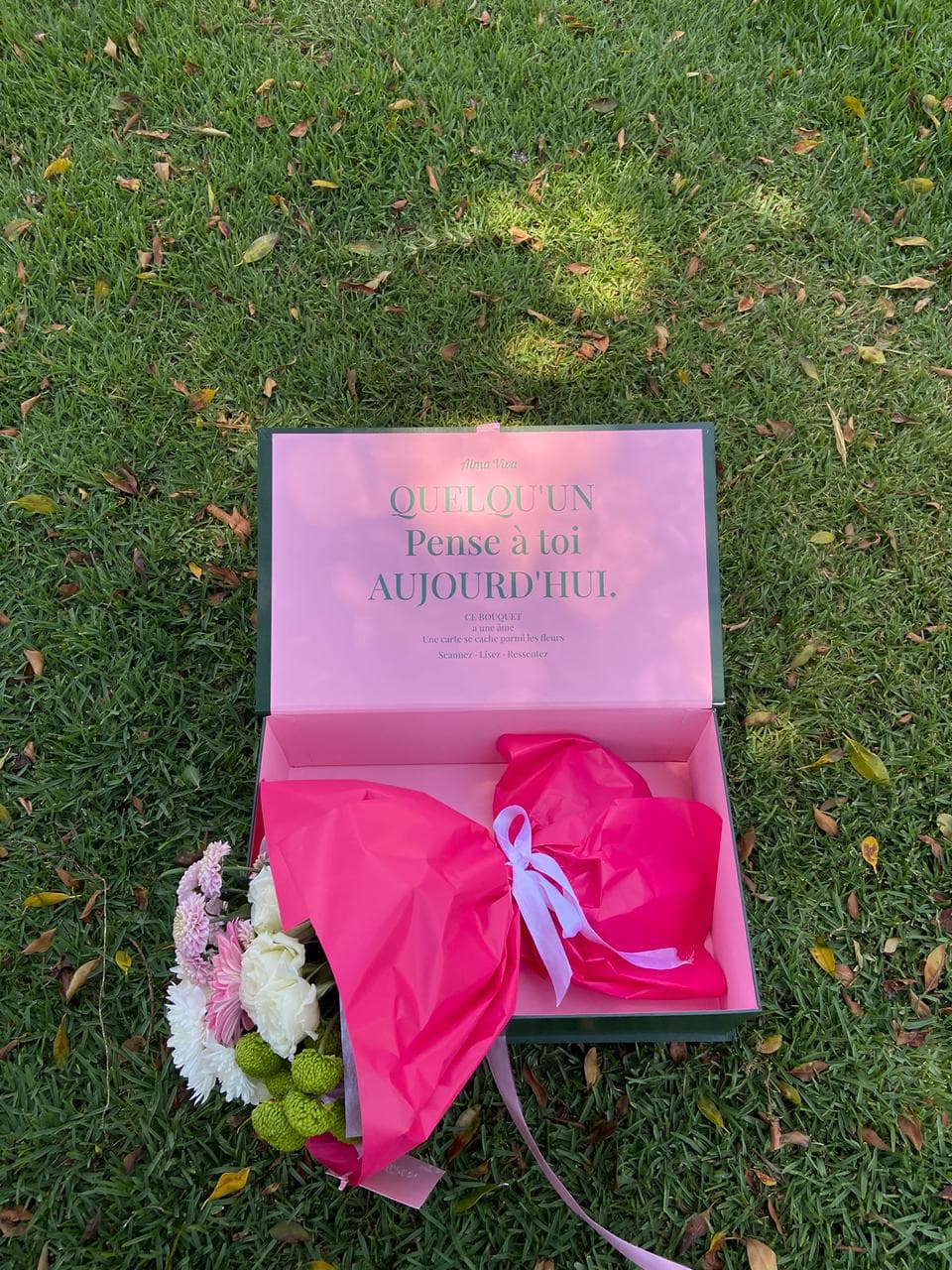 Bouquet enveloppé de papier fuchsia dans la boîte signature Alma Viva